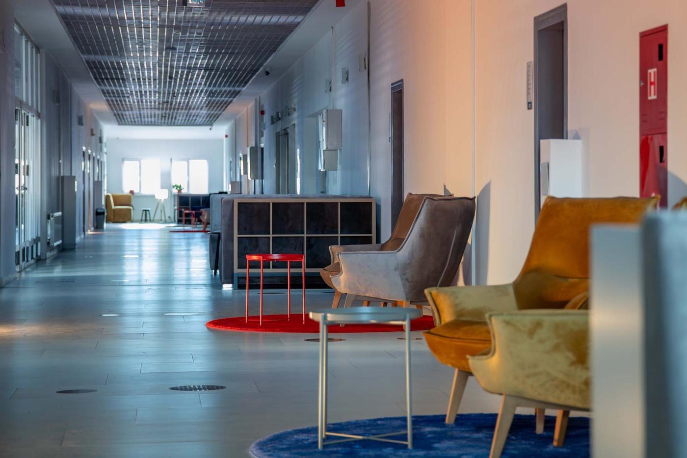A long corridor with armchairs, KALLAX shelving units and side tables.