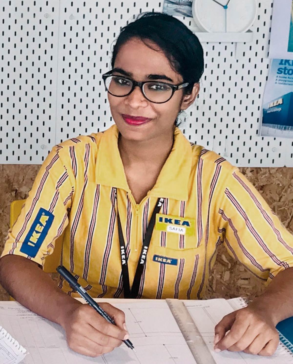 Portrait of a co-worker at the IKEA Hydrabad store wearing glasses and a yellow and blue t-shirt.