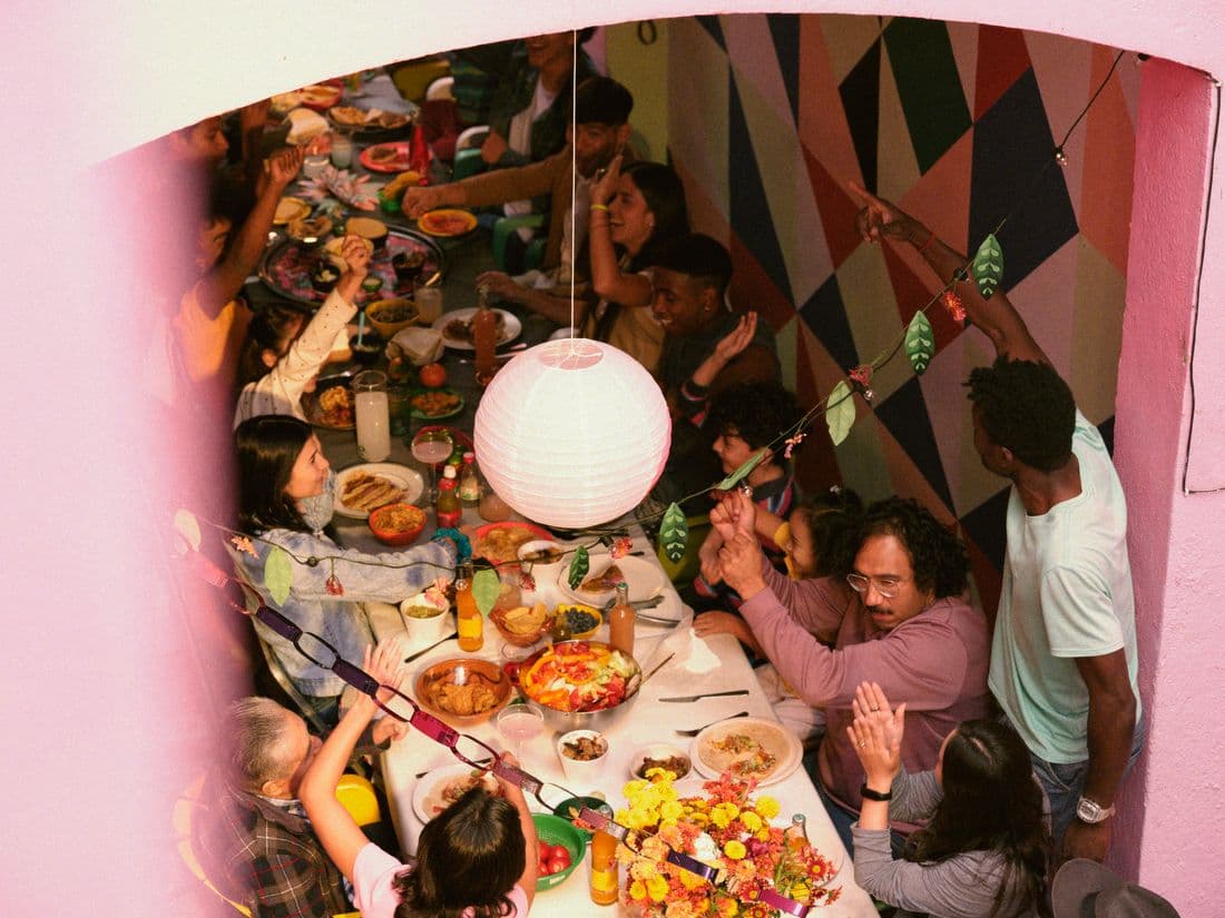 People sitting around a dining table set with festive decorations.