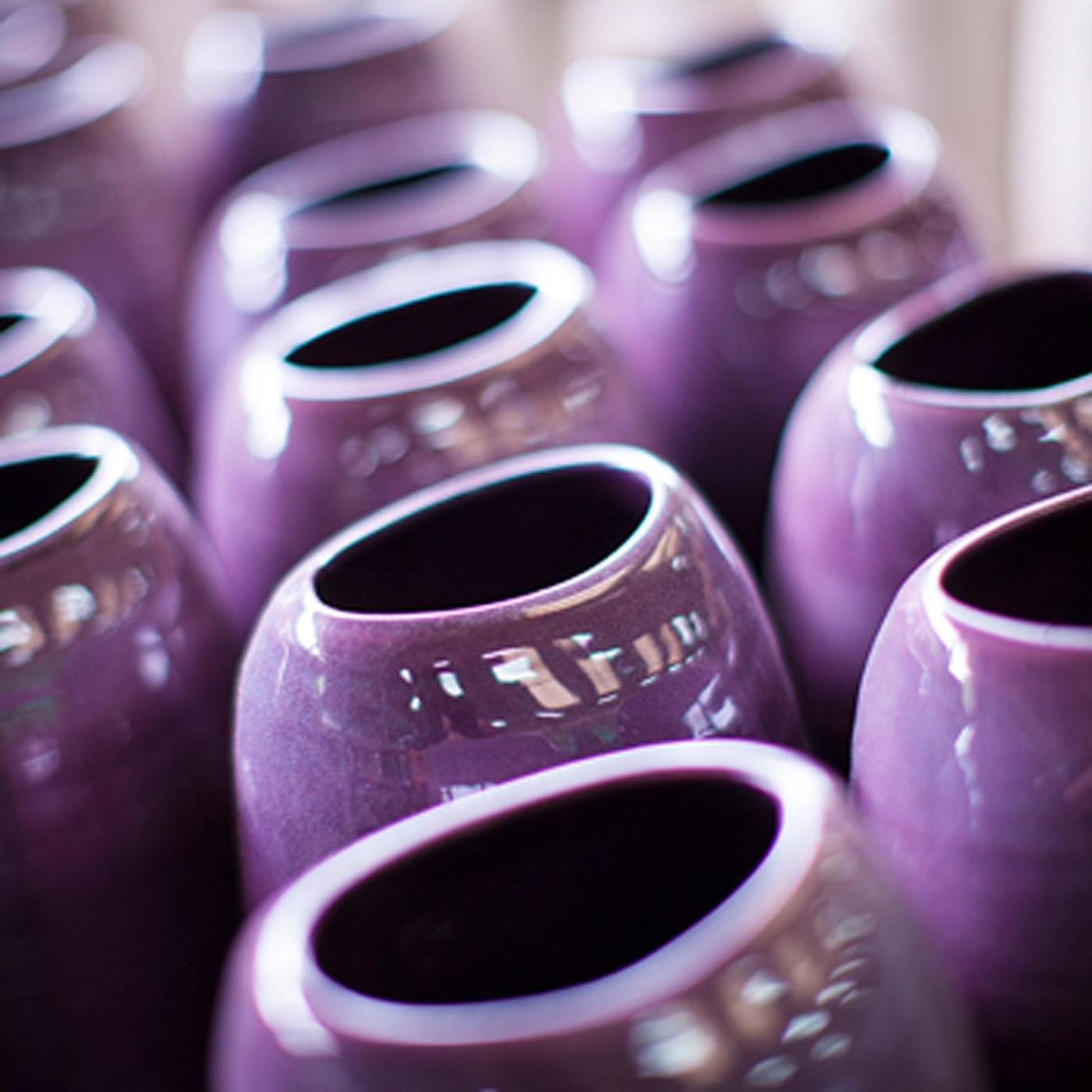 Several handmade INVERKAN ceramic vases with slightly irregular shapes and a lilac glaze standing close together.