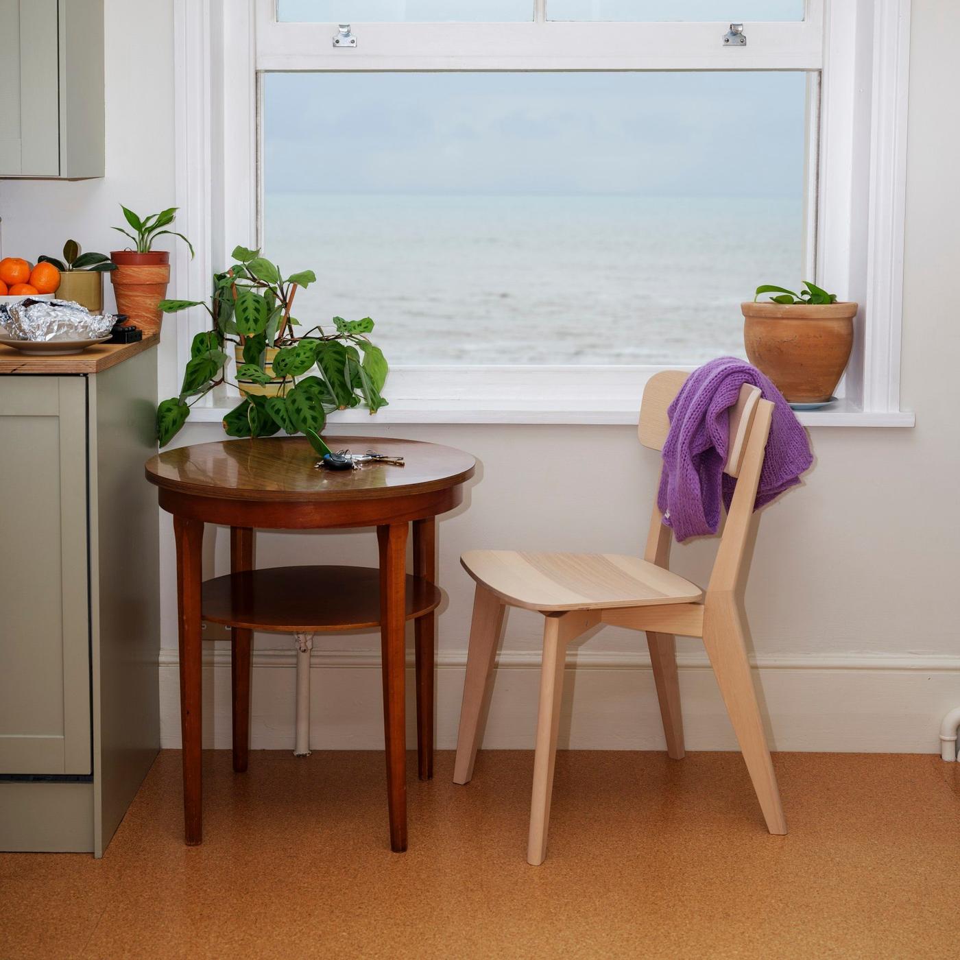 A chair and a table standing in front of a window