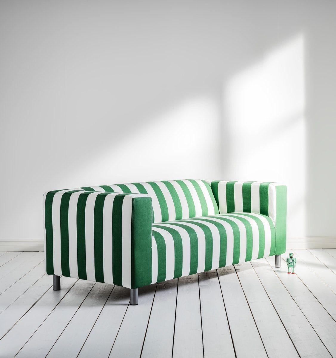 A striped green and white KLIPPAN sofa in a white room.