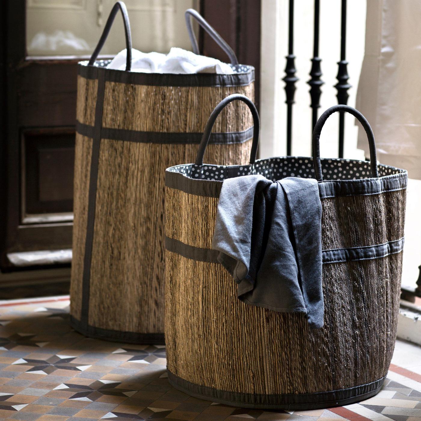 Two KRYDDAD laundry bags, one tall and one low and wide, made from renewable banana fibre and white and black fabric.