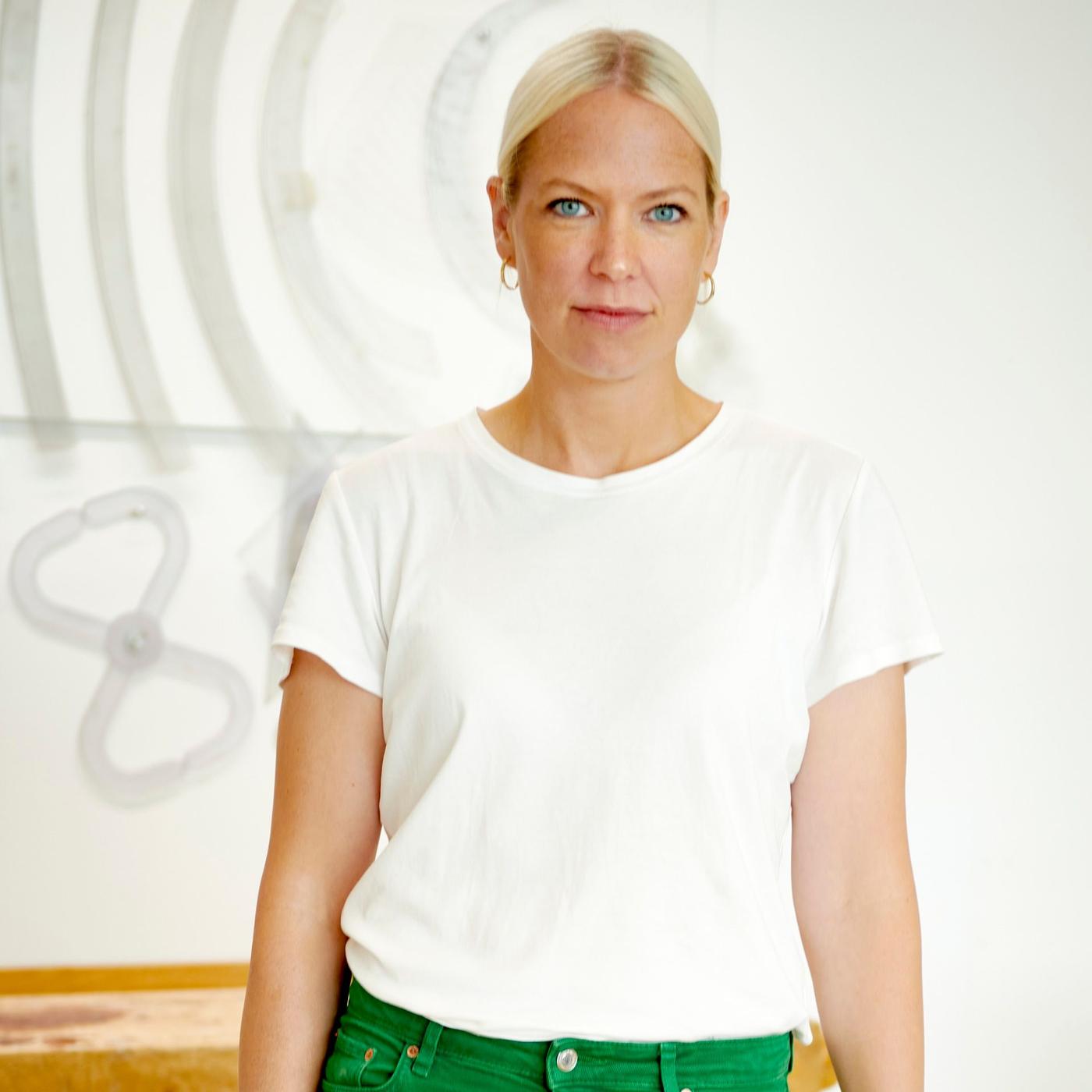 A portrait of a woman with white T-shirt and green pants.