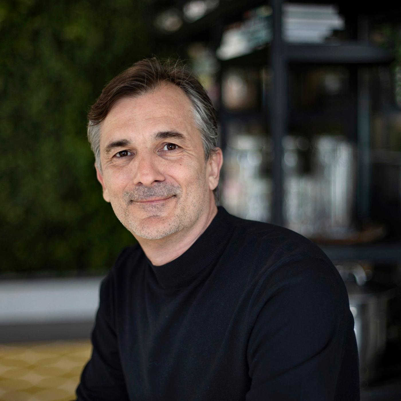 A portrait of a man in a black shirt.