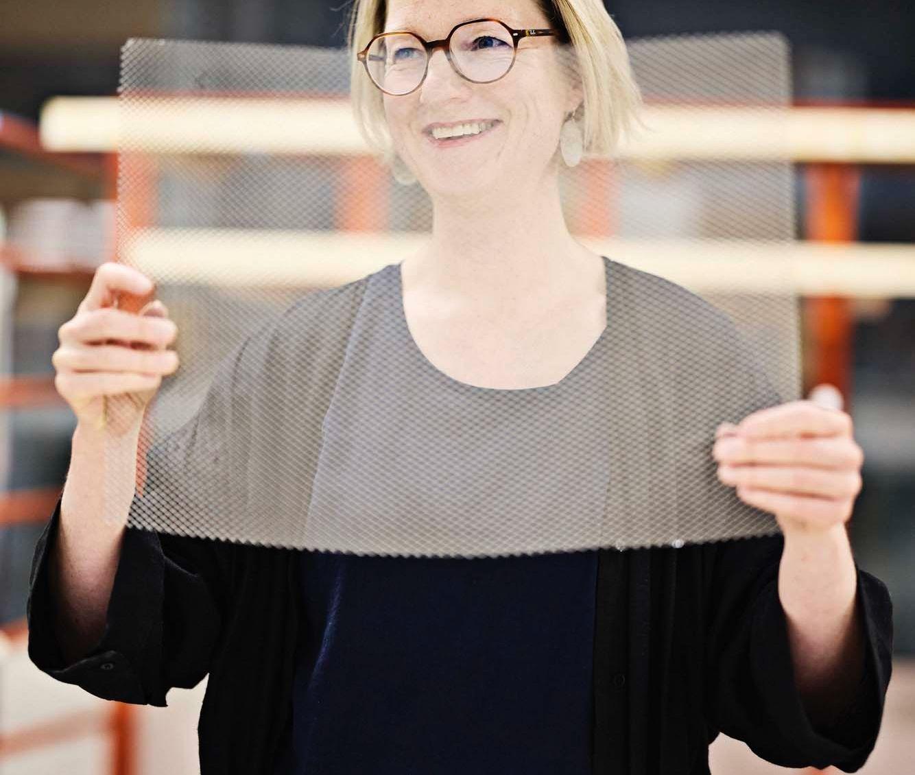 Designer Wiebke Braasch smiles as she holds up a piece of metal mesh used to make RISATORP baskets.