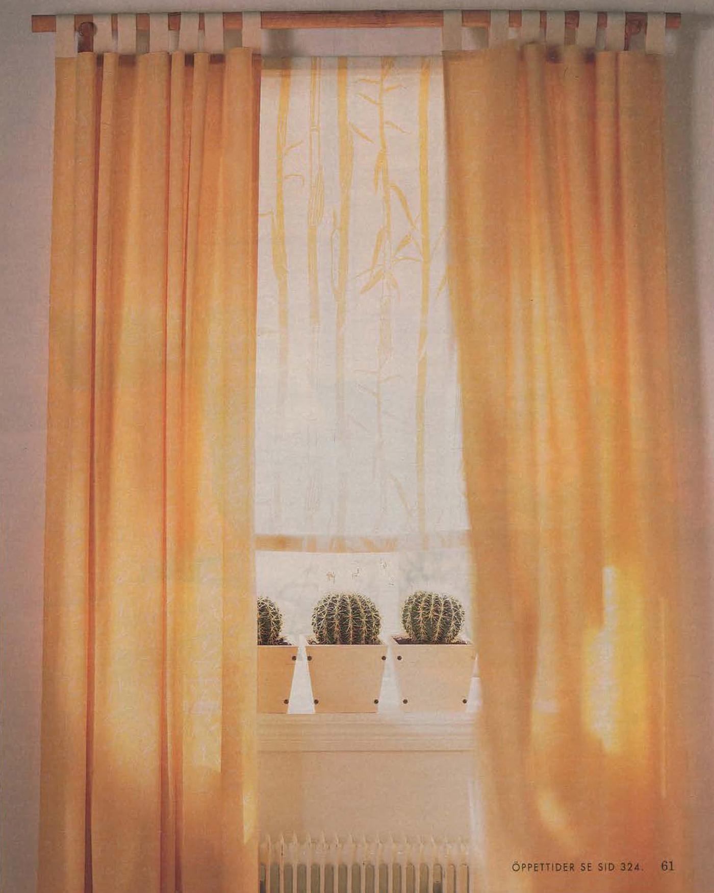 A pair of yellow curtains with white loops, hanging from a curtain pole.
