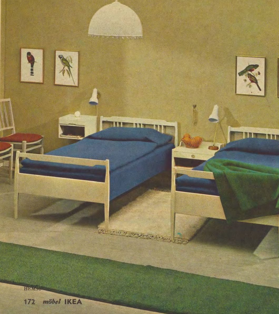 A bedroom room set from 1965 with two single beds separated by a night stand, upon which is a bowl of oranges.