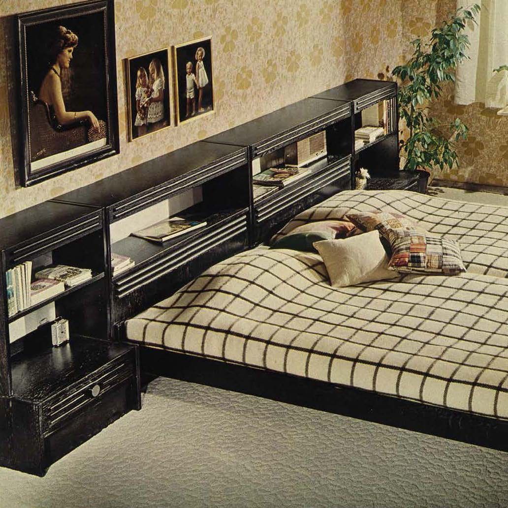 A double bed with black storage shelves/headboard. The bed has a black and white check cover.
