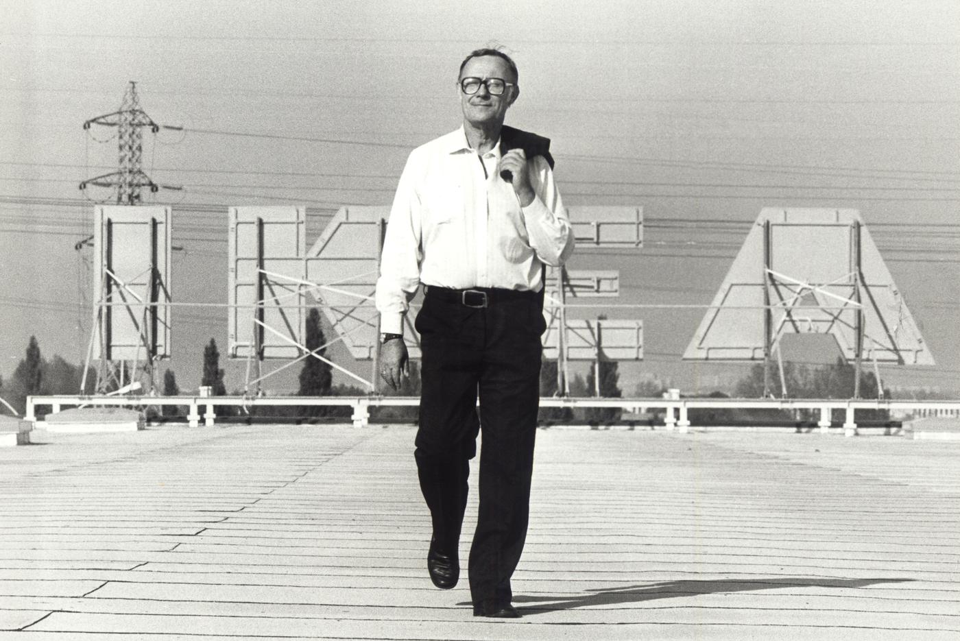 Ingvar Kamprad walks on the rooftop of an IKEA store, with the IKEA sign in the background.