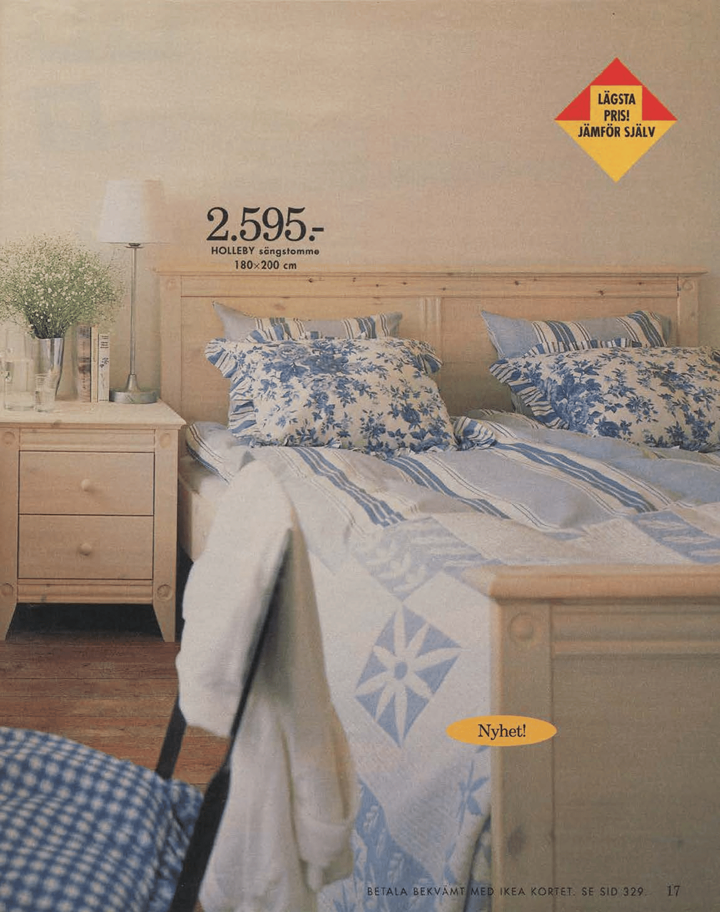 A light wood bed and bedside table from the 1996 catalogue. The bedlinen has a blue quilt design.