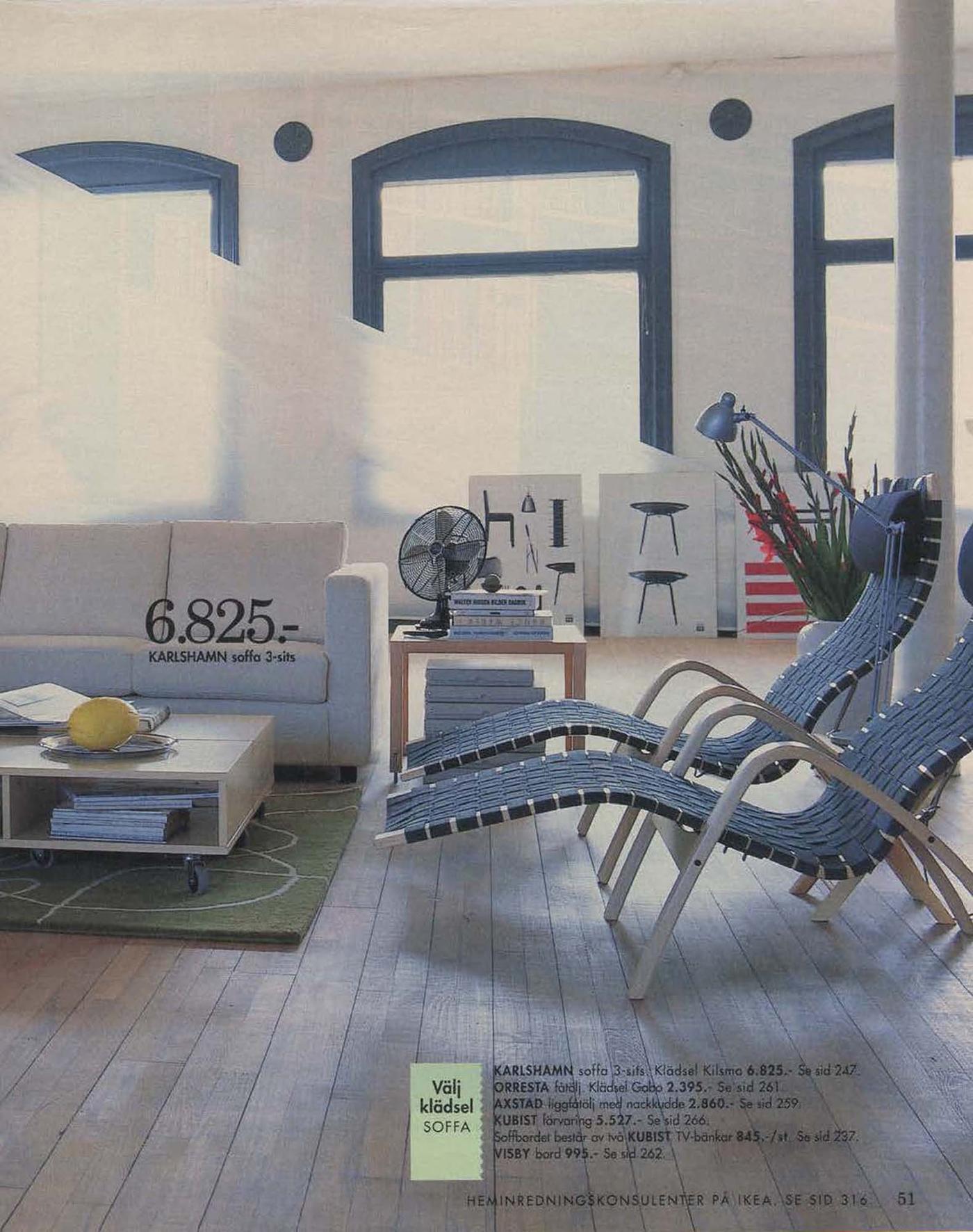 A loft style, open-plan living room area with two lounger chairs and large windows from the 1996 IKEA Catalogue.