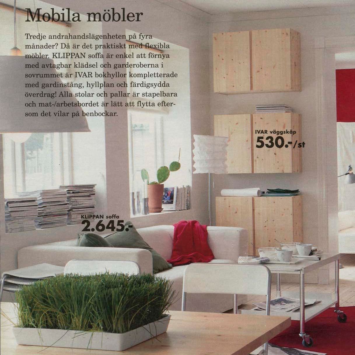 A white KLIPPAN sofa in a clean, bright living room with light woods and red accents.