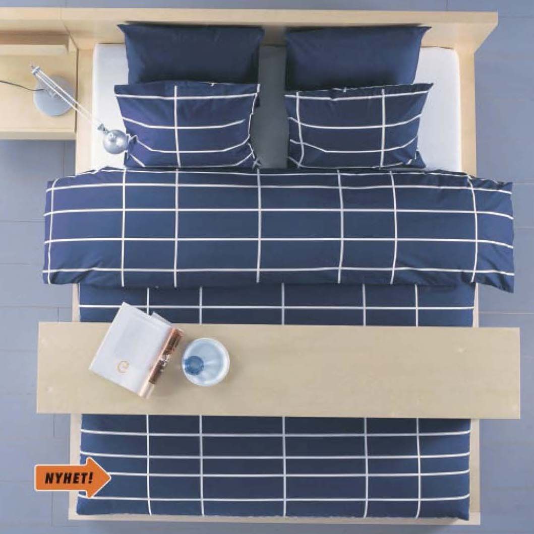 The 2004 IKEA catalogue showing an aerial image of a Japanese-inspired futon bed with navy windowpane check squares and a long wooden tray.