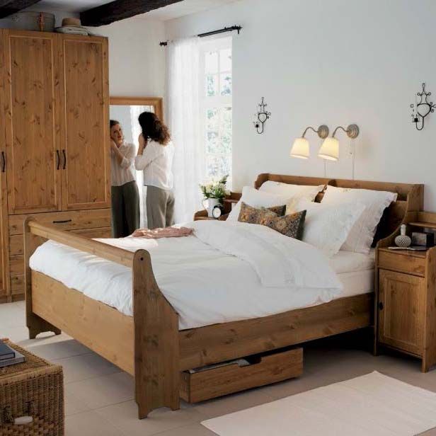The 2006 IKEA catalogue showing a wooden sleigh bed with white bedlinen in a white room with a wood wardrobe in the background.