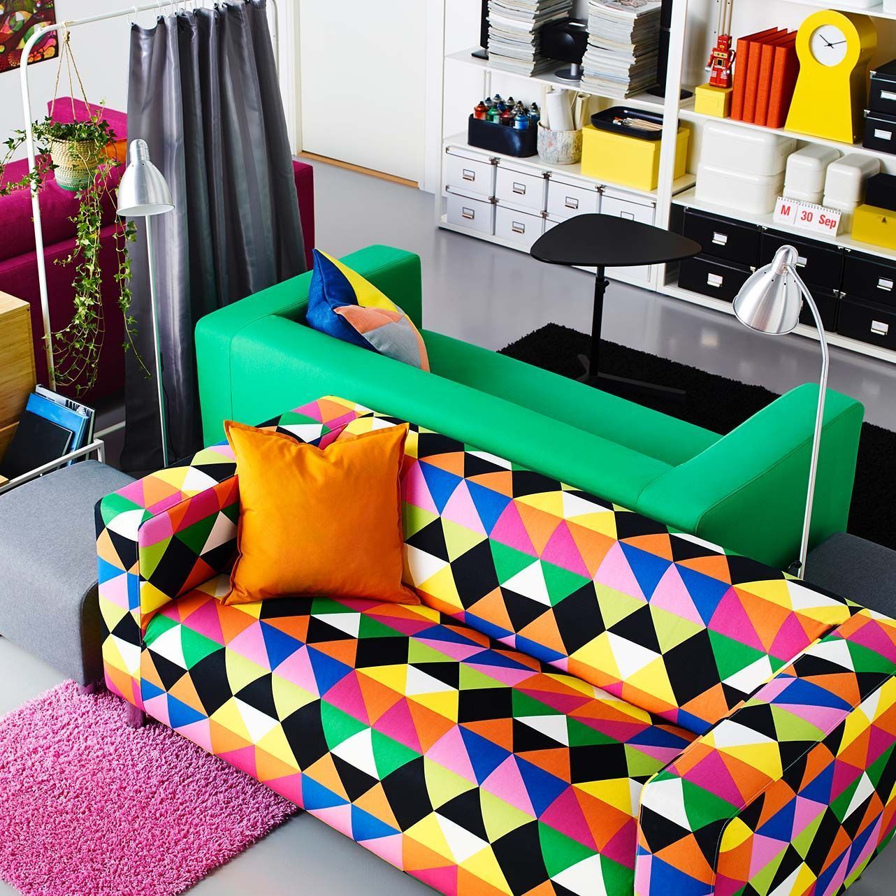 Two back-to-back KLIPPAN sofas pictured from above: one in bright green, the other in a multi-colour, triangular print. 