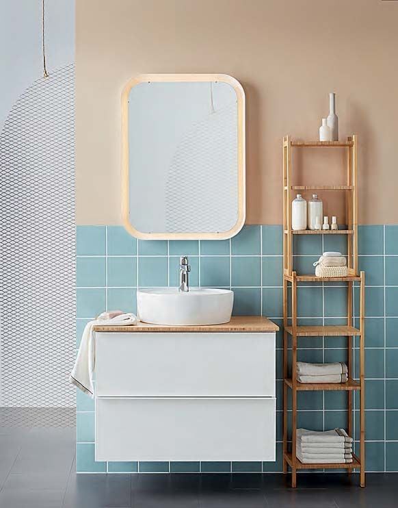 A cream and blue tiled bathroom. There is a wall hung cabinet, wall hung vanity unit and wood shelves.