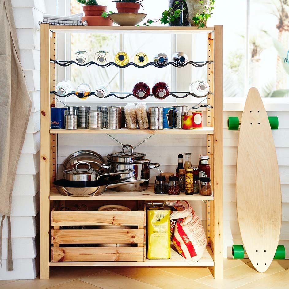 Wooden shelves stacked with cookware and bottles, next to a skateboard.