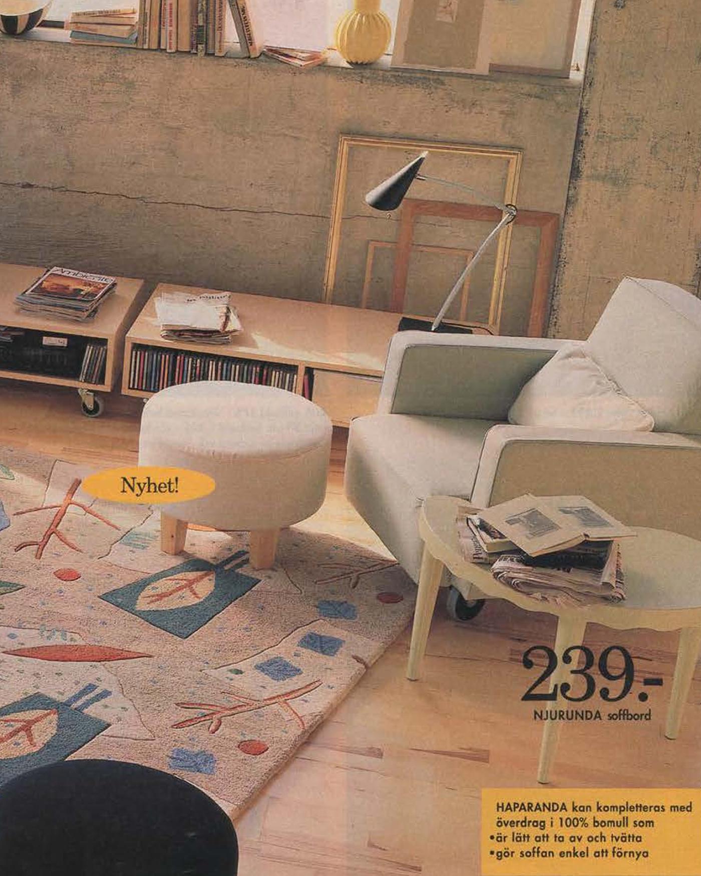 A loft style living room with an armchair, footstool and light wood, low media units on castors from the 1996 catalogue.