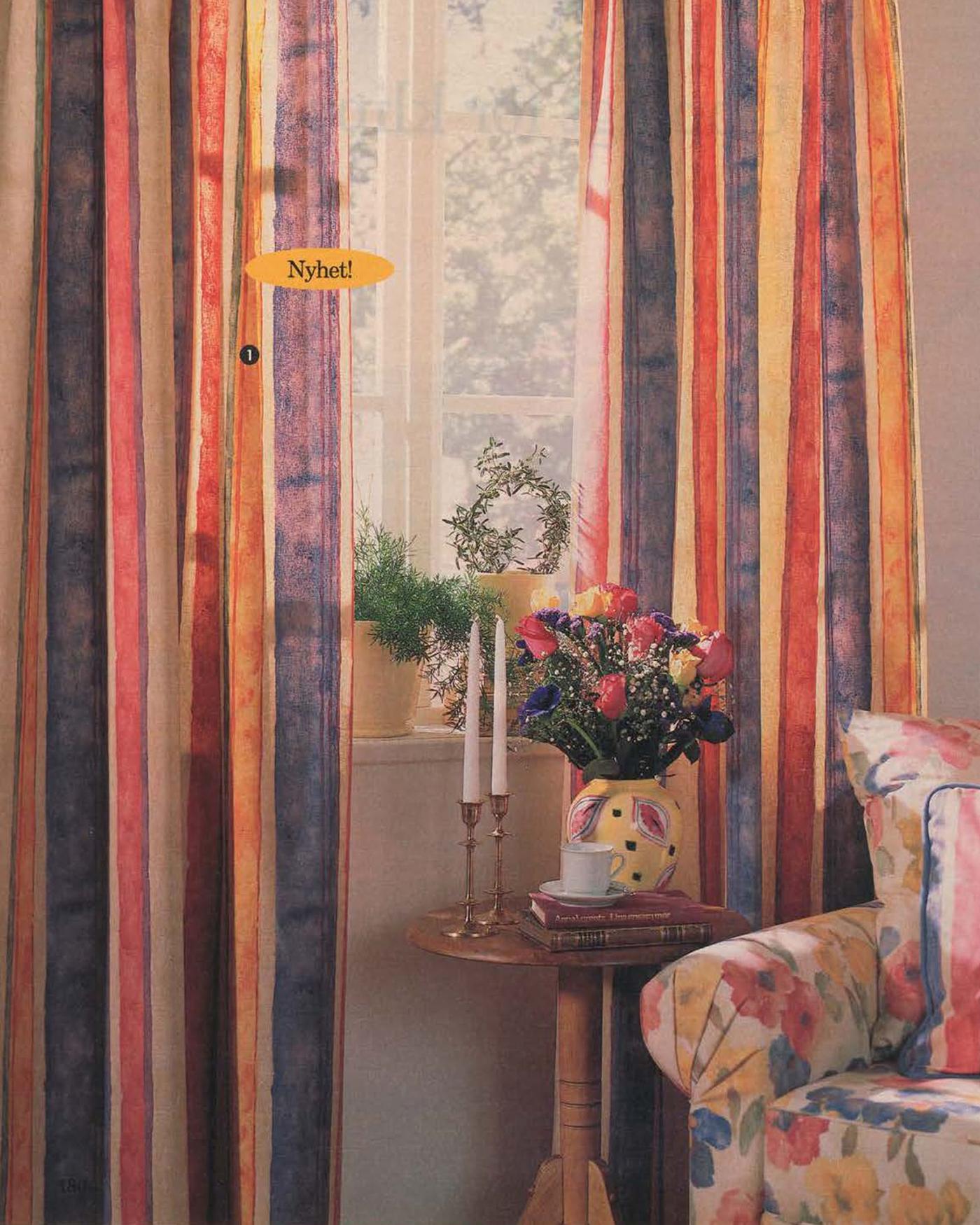 A pair of brightly coloured striped curtains next to a round table and a floral upholstered chair from the 1996 IKEA Catalogue.