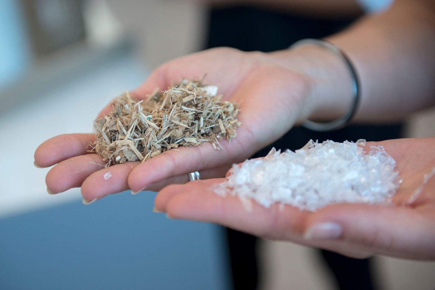 Hands holding the plastic and the wood used to make KUNGSBACKA kitchen fronts.