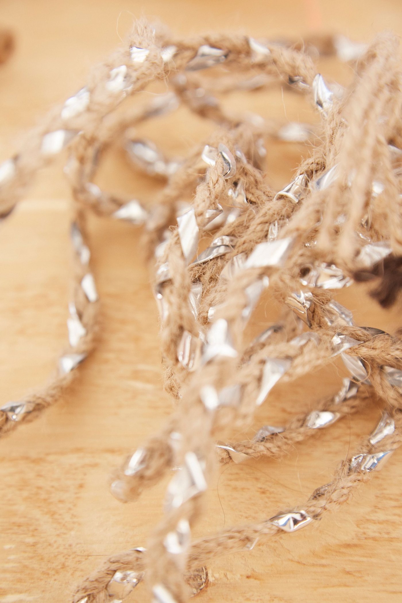 Natural string with interwoven shiny plastic.