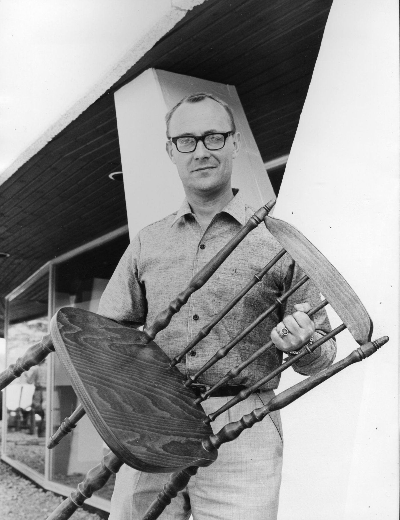Black and white photo of Ingvar Kamprad holding a chair.