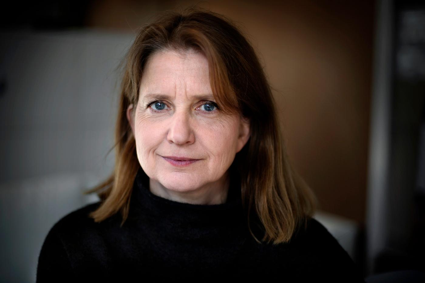 A woman in a black shirt looking at the camera.