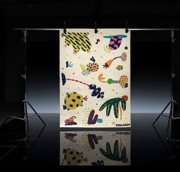 Colourful and eclectic rug displayed in a black room with dramatic lighting.