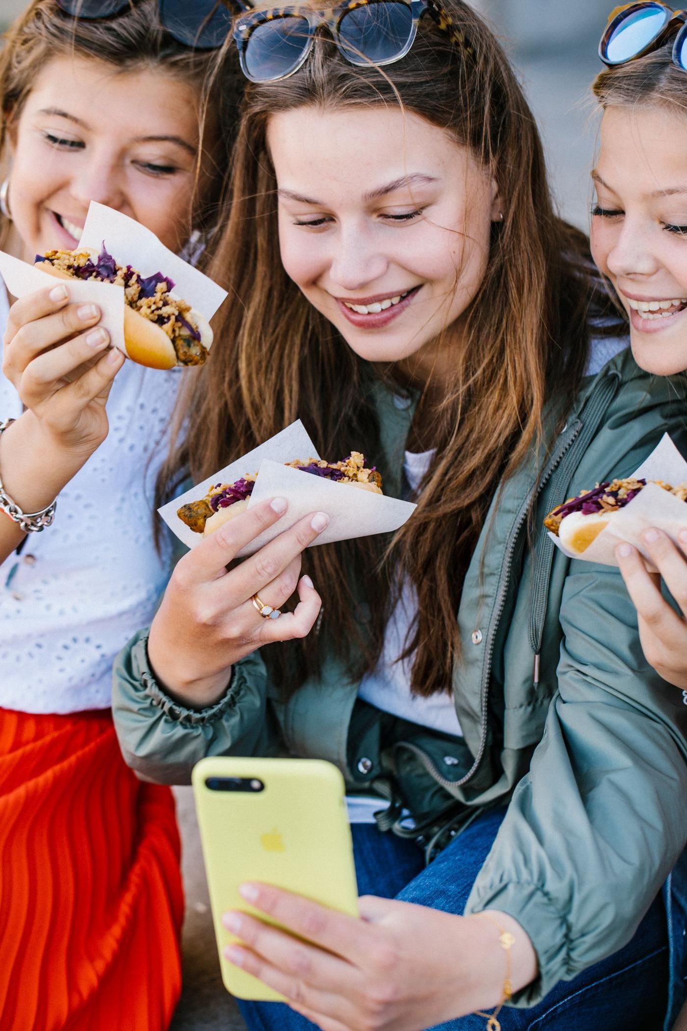 Teens enjoying the veggie hotdog.