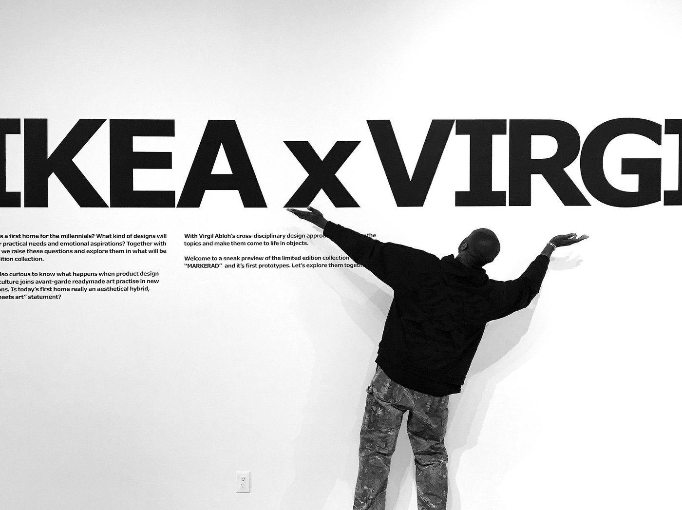 A person with extended arms faces a wall with large text reading, "IKEA x VIRGIL"