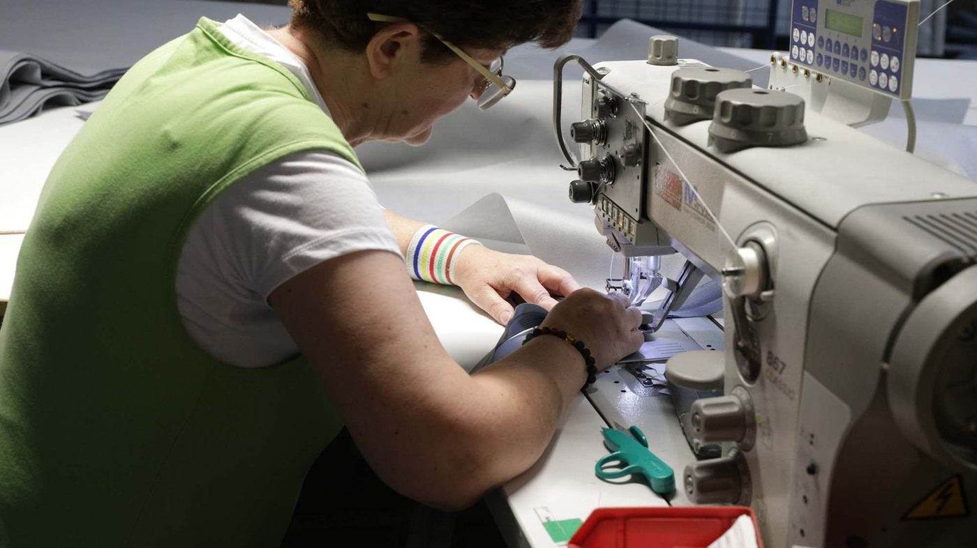 A person sews on a sewing machine.