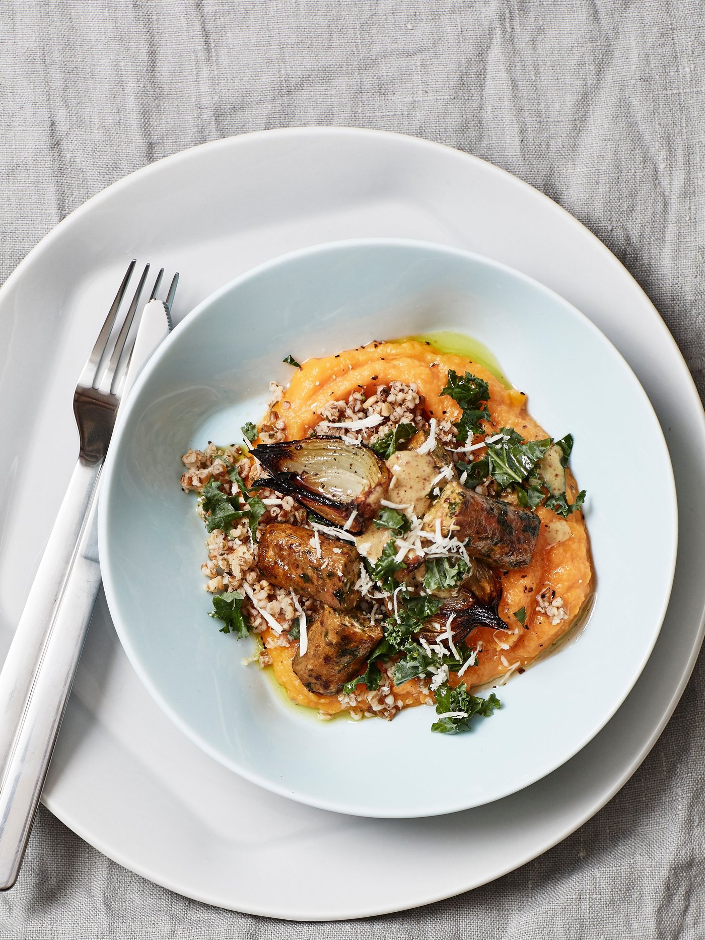 A plate of butternut squash, mixed grains, mushrooms and KORVMOJ veggie hot dogs.