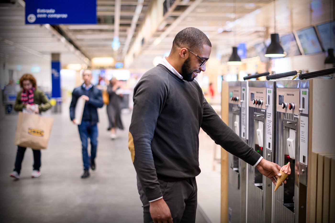A person stands at an ice cream dispensing machine at an IKEA Bistro