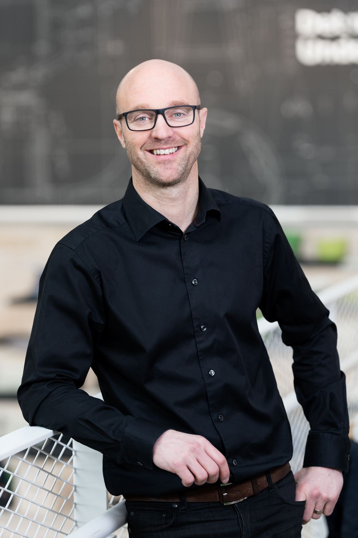 Portrait of Björn Block wearing glasses and a black shirt.