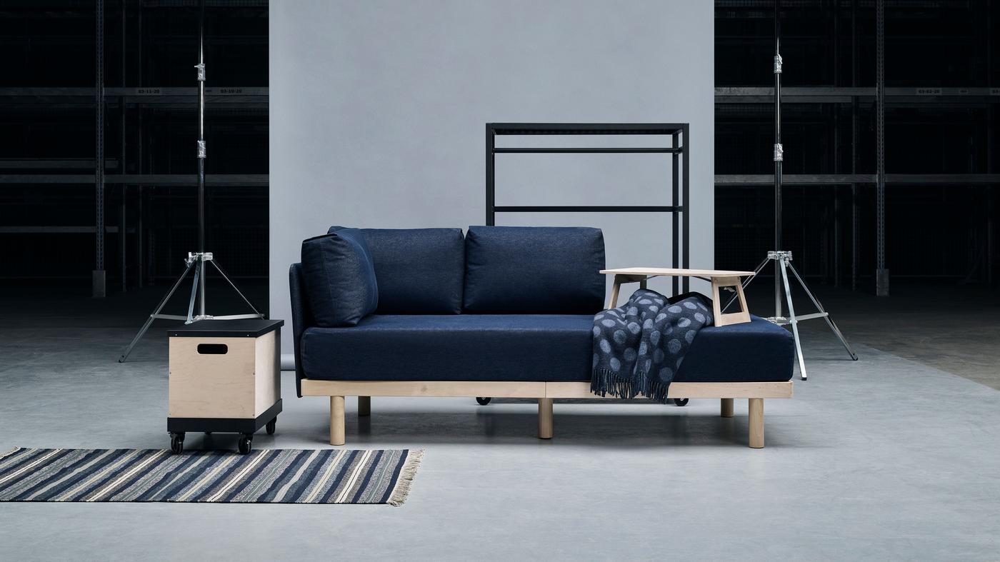 Products from the RÅVAROR collection on display, including a day bed, shelving unit and storage box on casters.