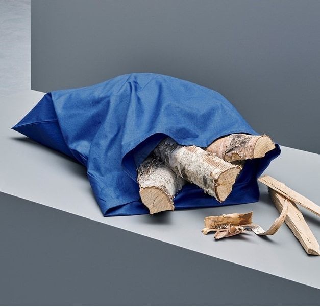 A blue fabric bag filled with pieces of cut wood.