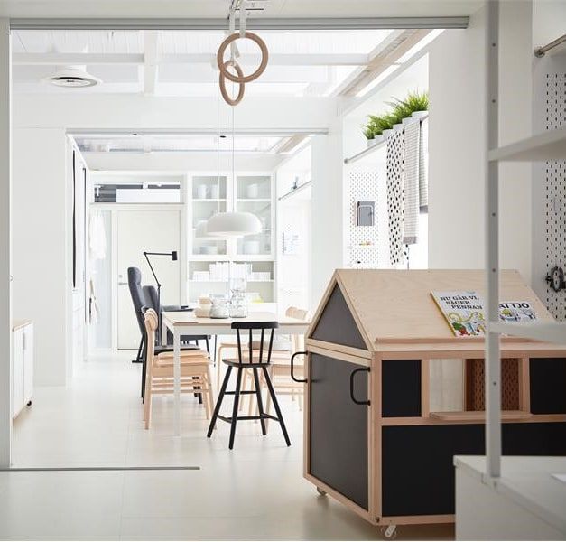 Light, white apartment with dining area and small playhouse.