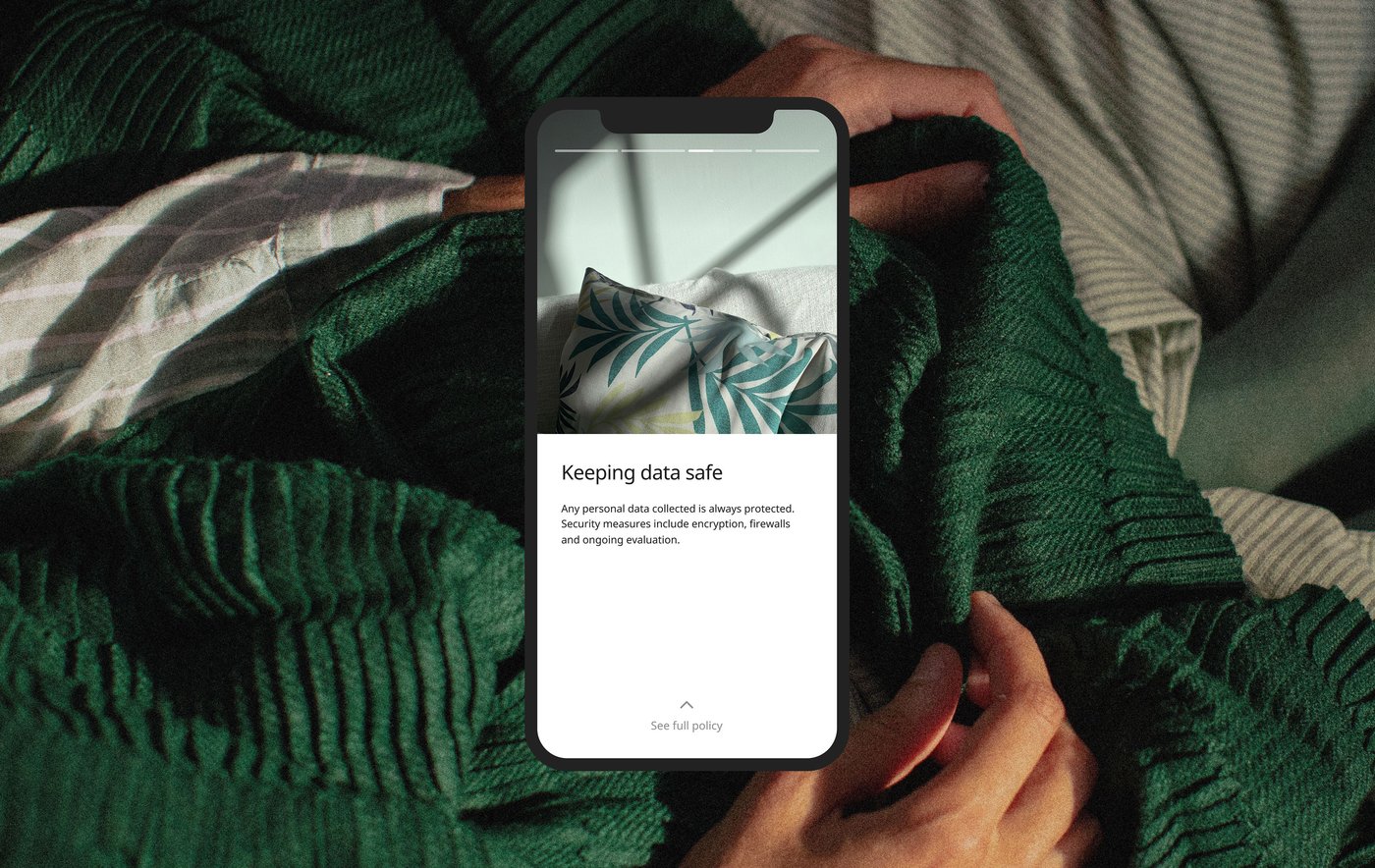 Close up photo of a dark green knitted throw draped over a person's body, overlaid with a smartphone screen with text reading "Keeping data safe".