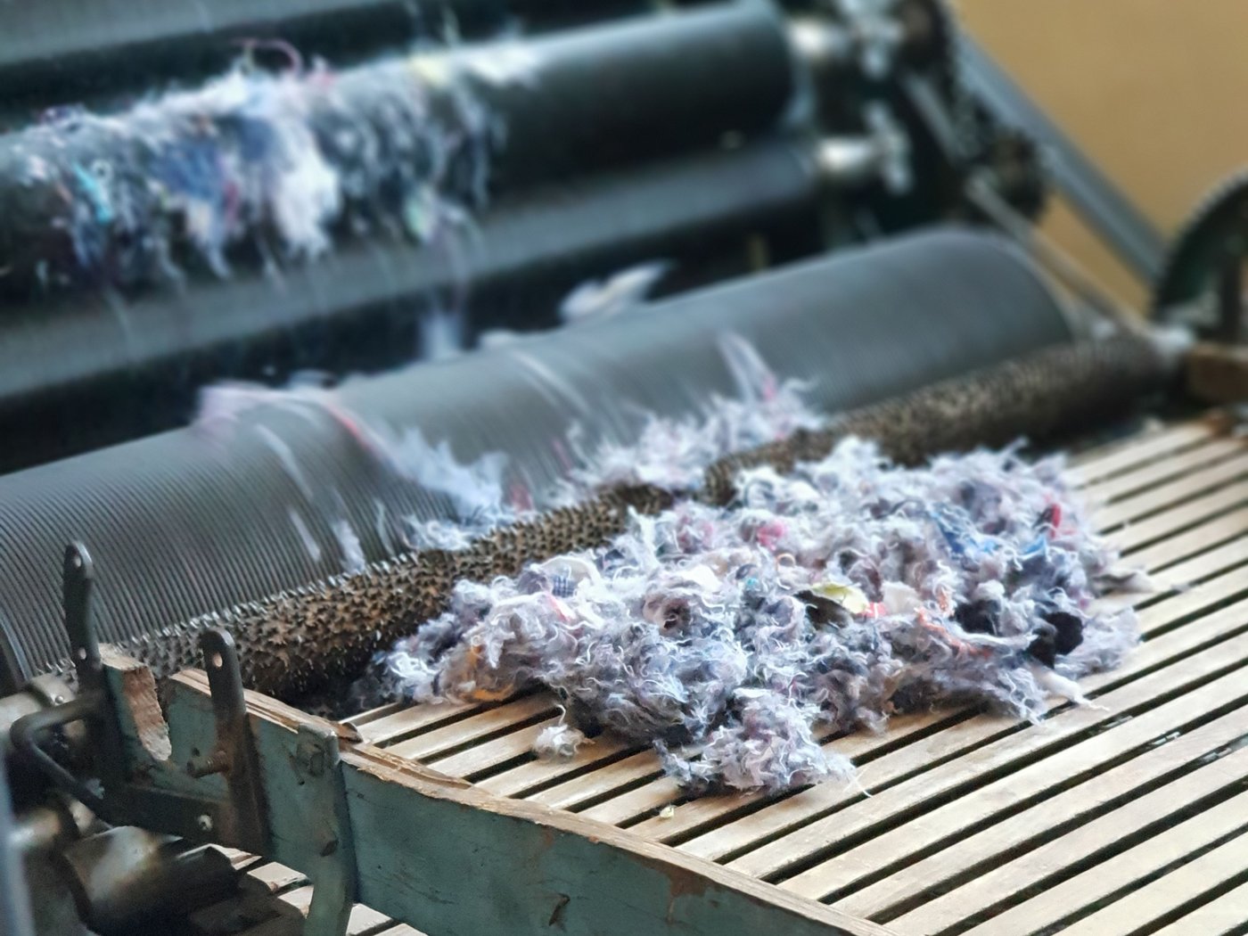 Post-consumer recycled textile fibres being processed.