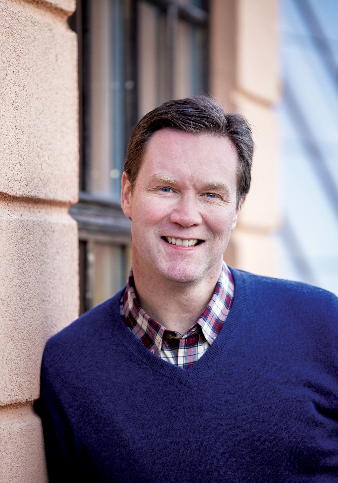 A man looks at the camera. He is smiling.
