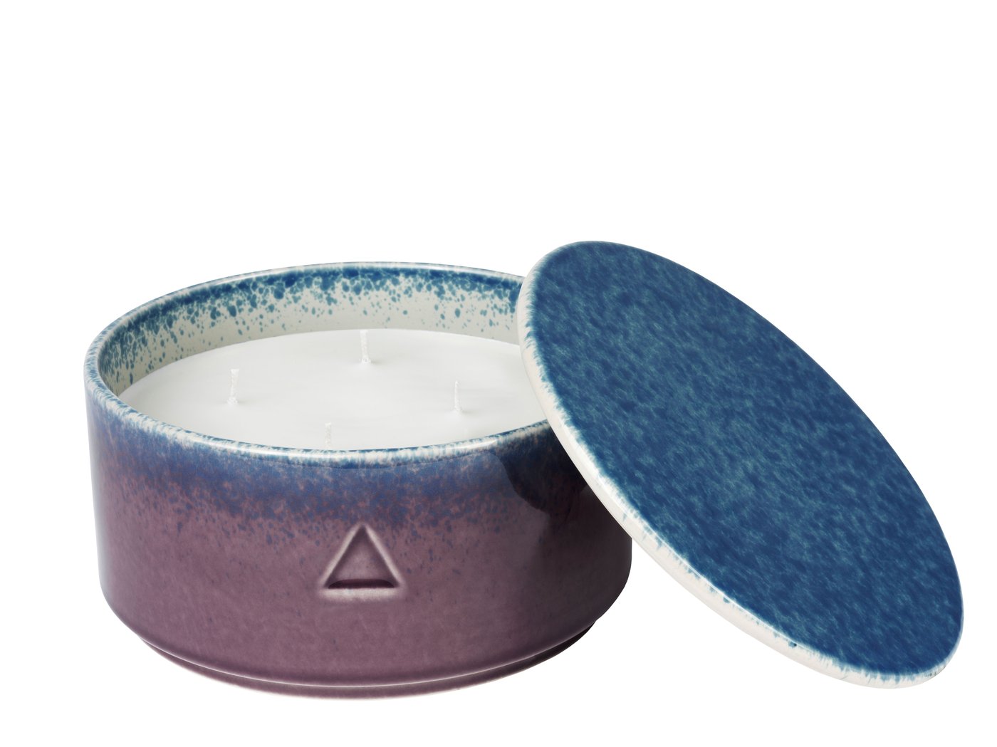 A dark purple and blue ceramic handle holder with a candle inside. Against a white background.