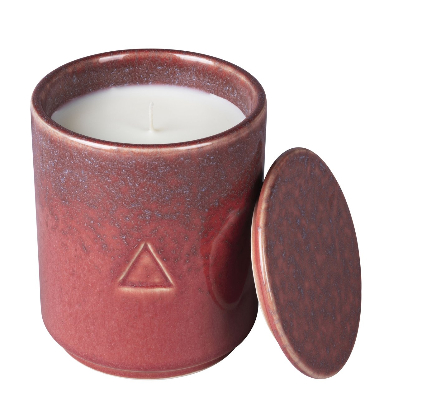 A dark pink ceramic handle holder with a candle inside and a lid leaning against it. Against a white background.