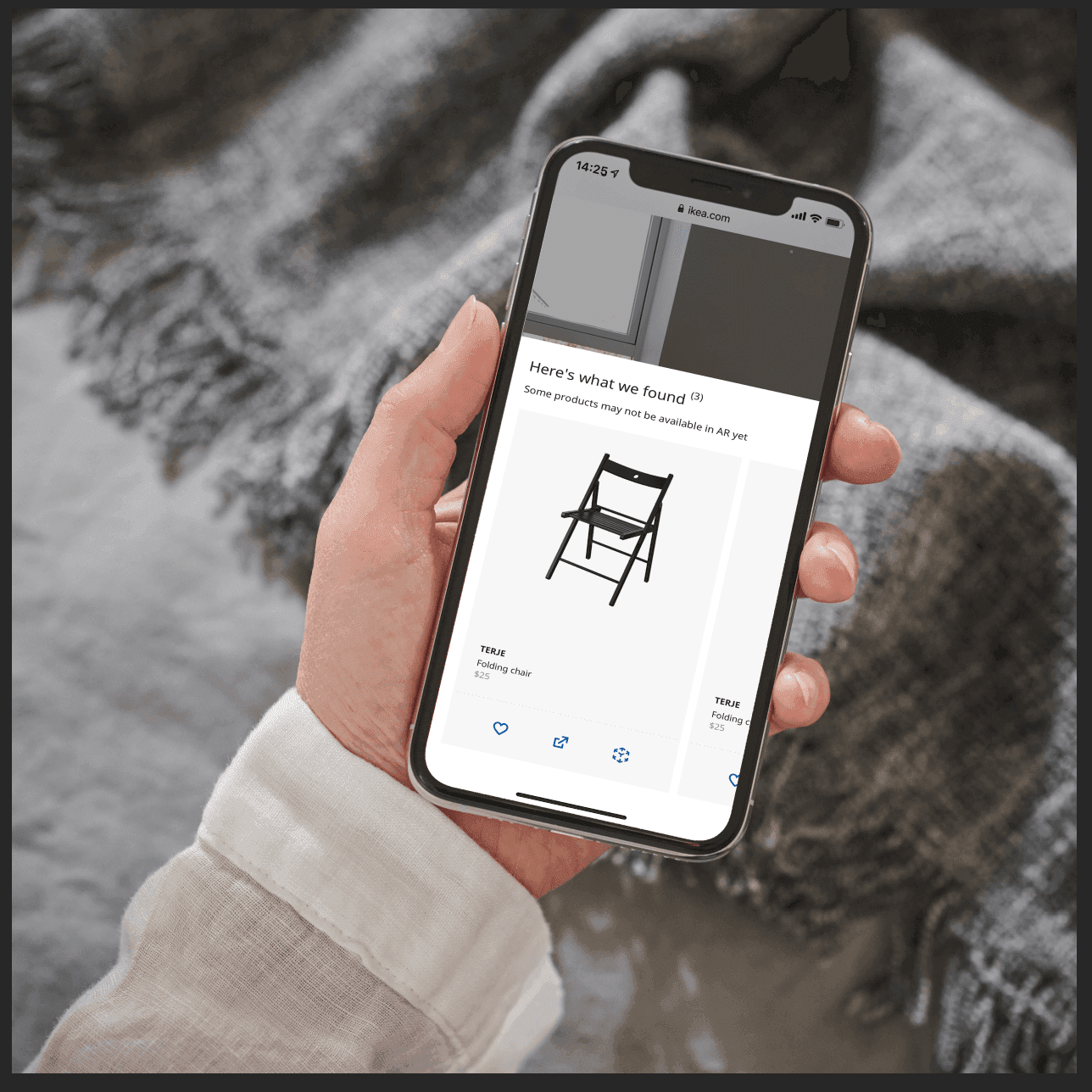A person holds a smartphone. The screen shows a black chair on a white background.