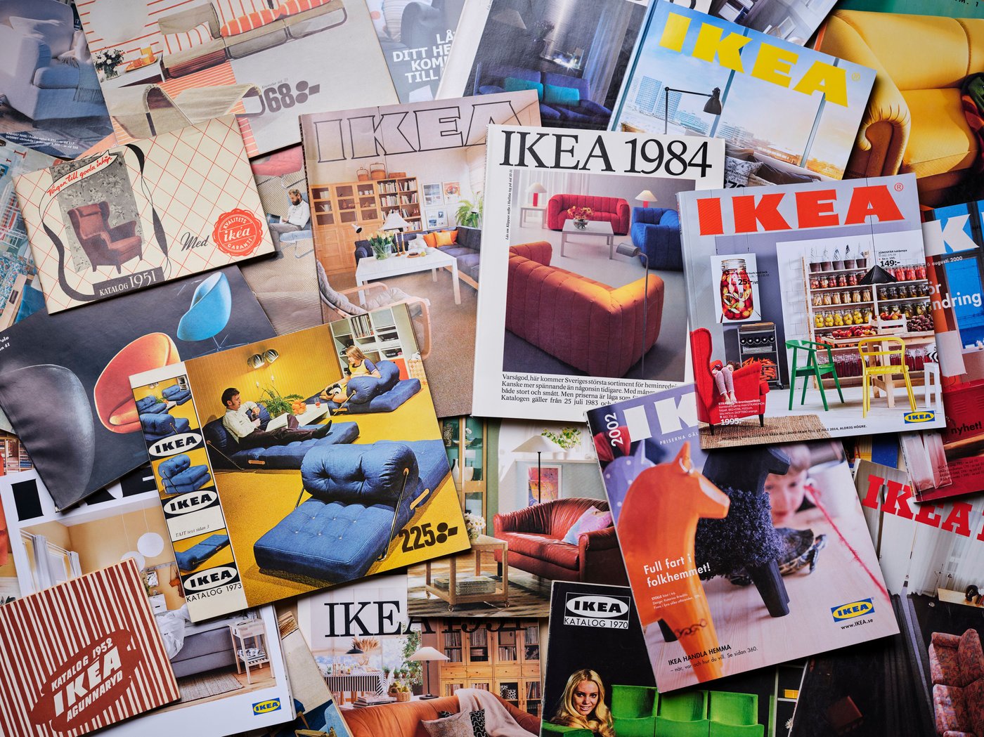 A collection of IKEA Catalogues are spread out on a flat surface.