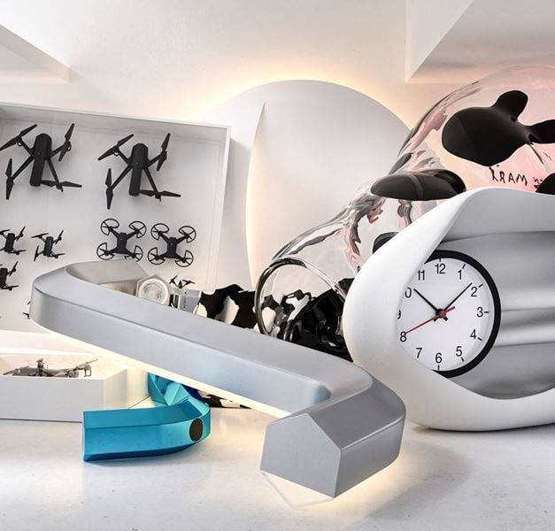 A collection of art pieces: An allen key light, a white clock, drones and a light.