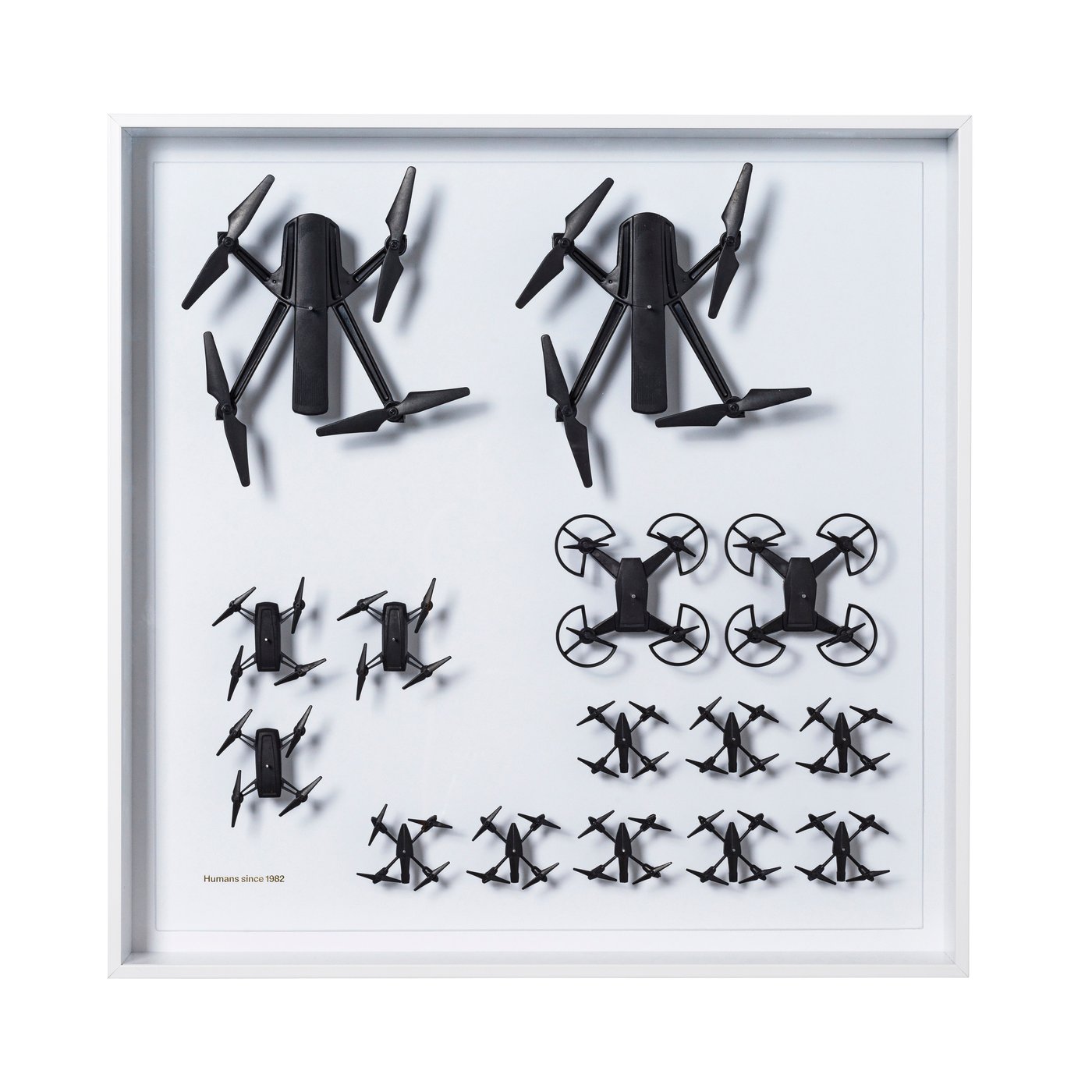 A collection of black drones framed in a white clear presentation frame.