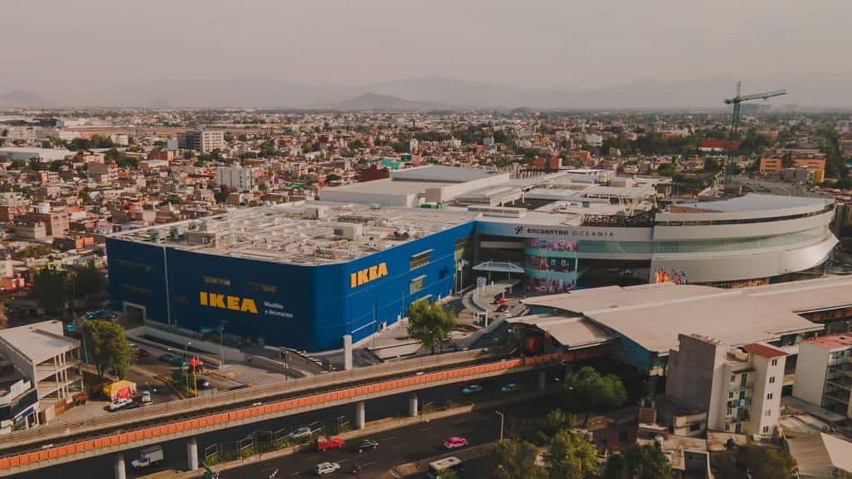 A photo of Mexico city. In the centre of the photo is a large blue IKEA store. It is surrounded by buildings.