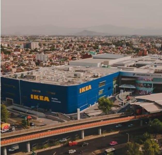 A photo of Mexico city. In the centre of the photo is a large blue IKEA store. It is surrounded by buildings.