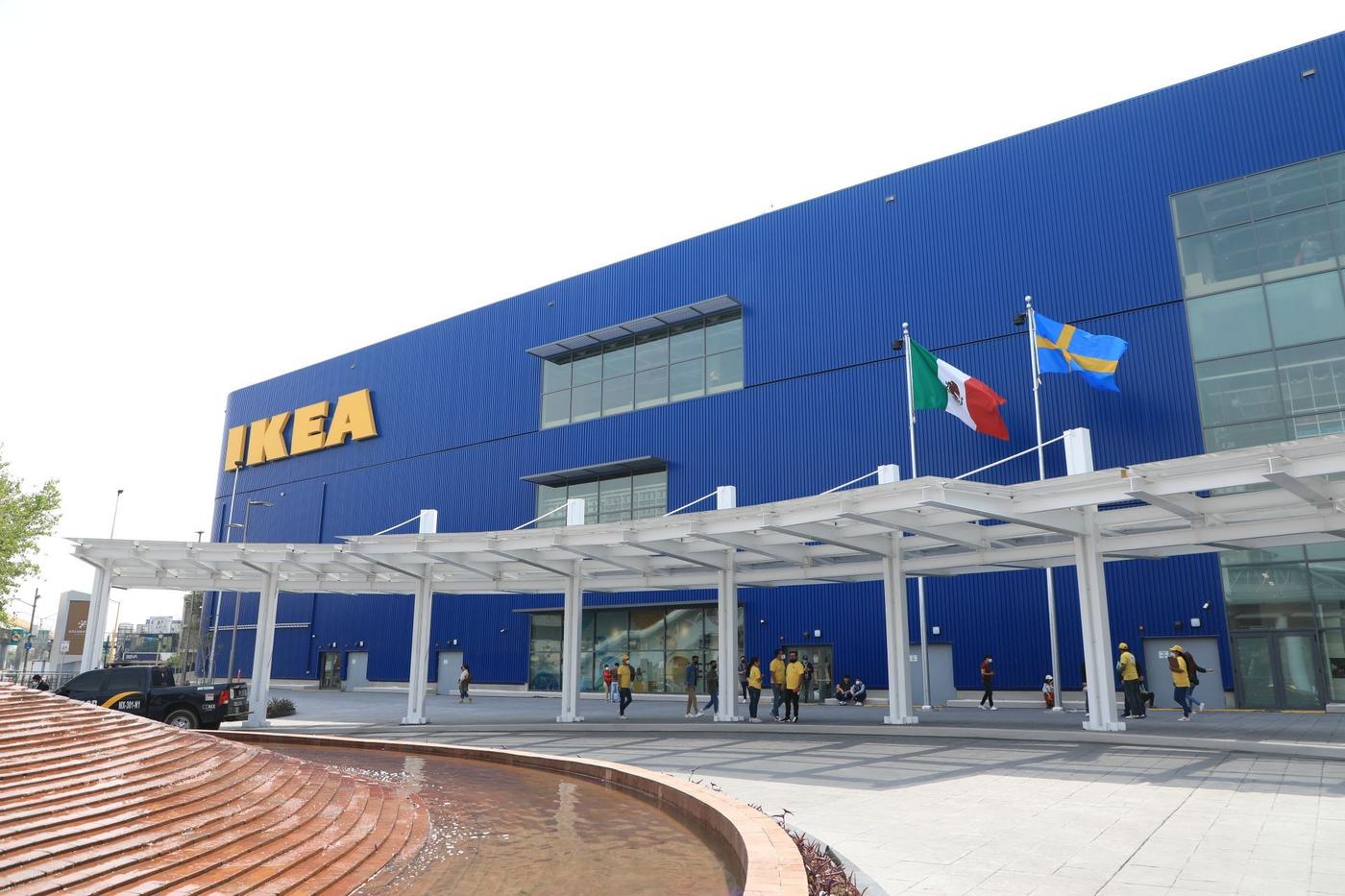 The blue facade of an IKEA store. It has a covered walkway and a water feature.